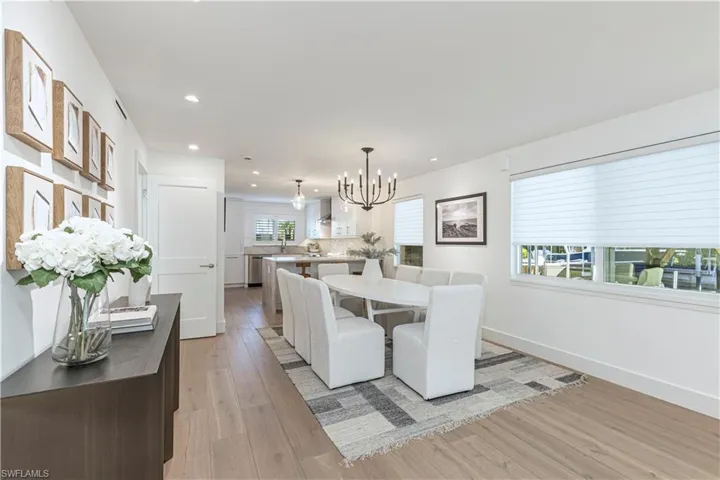 Dining space with light wood-style floors, recessed lighting, baseboards, and an inviting chandelier
