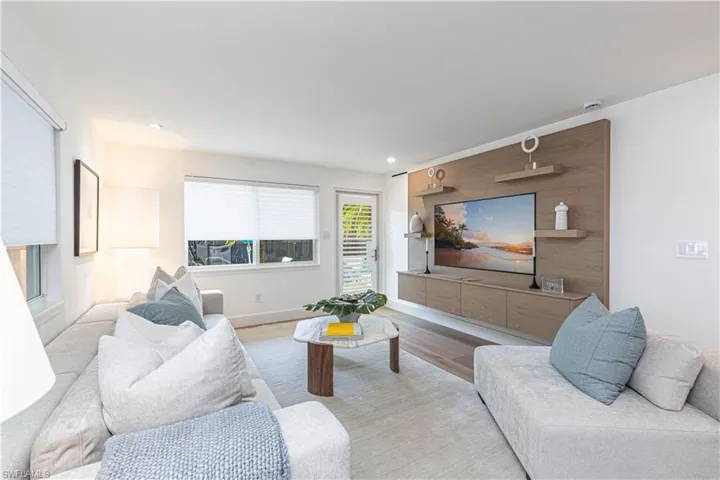 Living room featuring light wood-style floors, baseboards, and recessed lighting