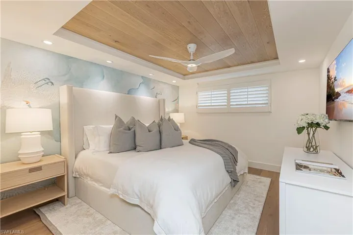 Bedroom featuring light wood-style floors, wood ceiling, a tray ceiling, and recessed lighting