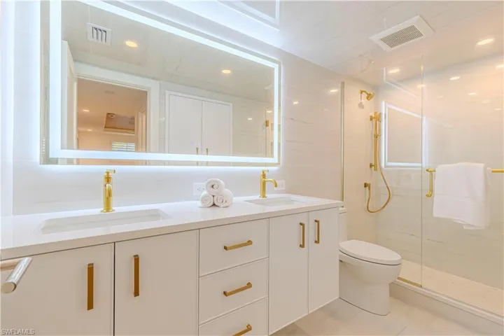 Bathroom with a sink, visible vents, and a shower stall