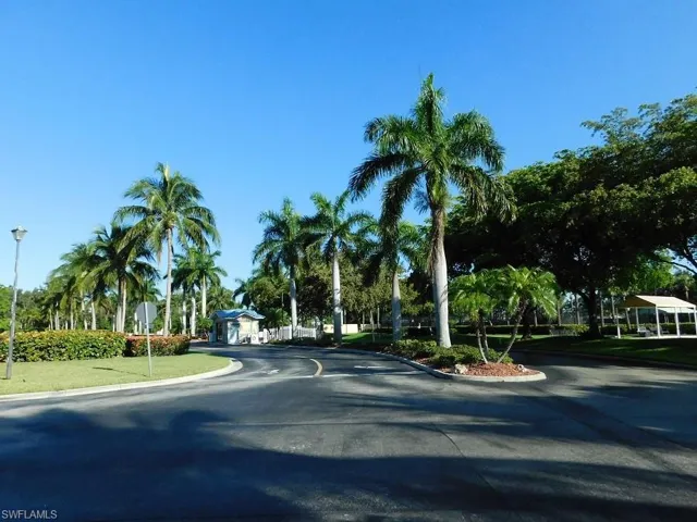 View of asphalt road featuring curbs, street lights, and traffic signs