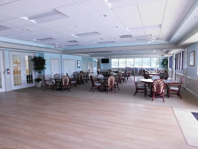 Dining room with ceiling fan, light colored carpet, a paneled ceiling, and light wood-style floors