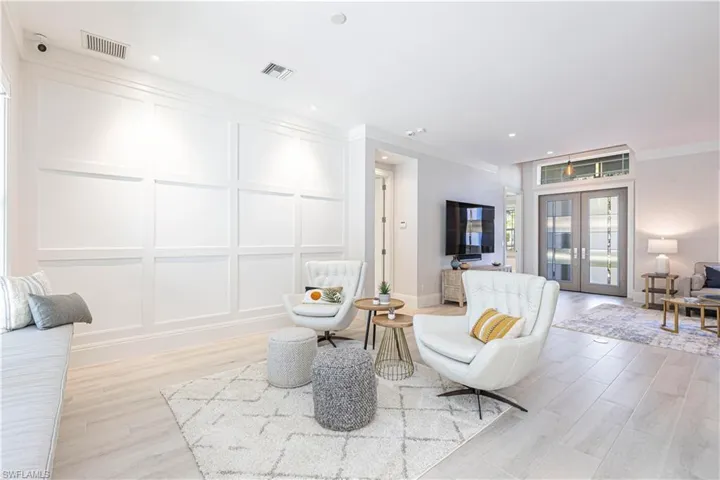 Sitting room with light hardwood / wood-style flooring, crown molding, and french doors