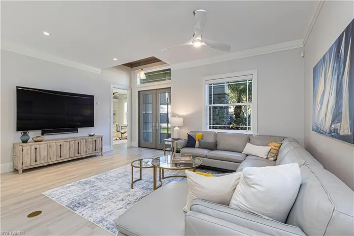 Living room with ceiling fan, french doors, ornamental molding, and light hardwood / wood-style flooring