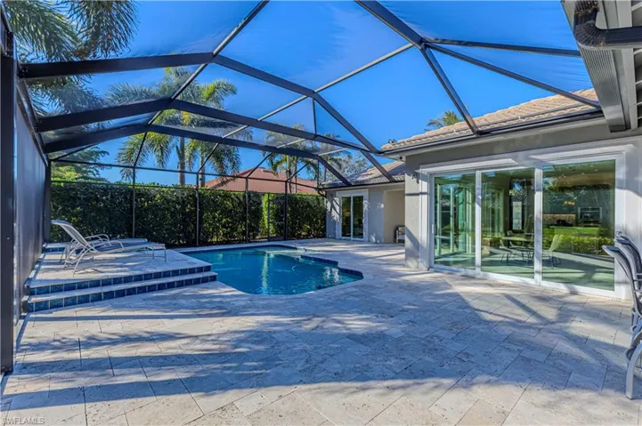 View of swimming pool with a patio and glass enclosure