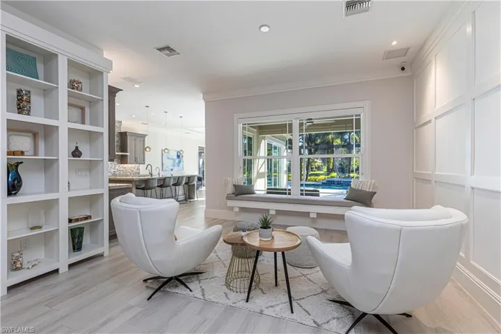 Sitting room with light hardwood / wood-style flooring, ornamental molding, and sink