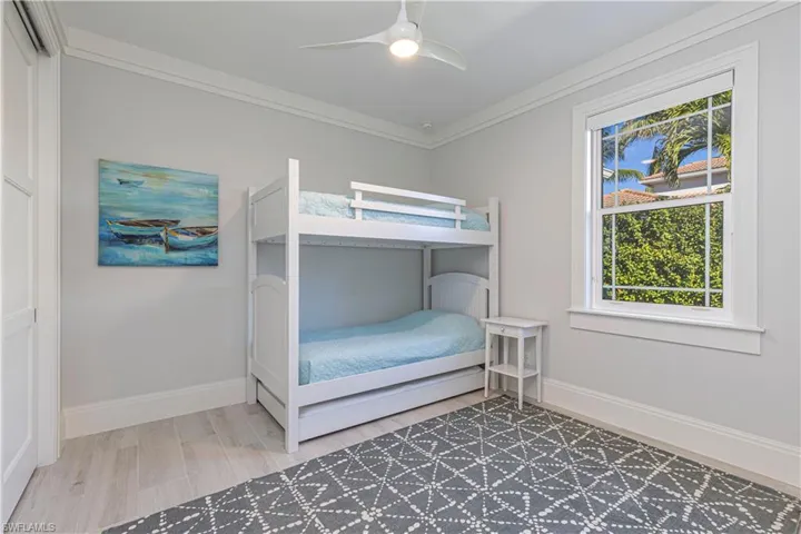 Bedroom featuring ceiling fan and ornamental molding