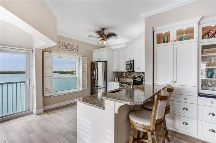 Stainless appliances, granite counters, and white cabinetry.