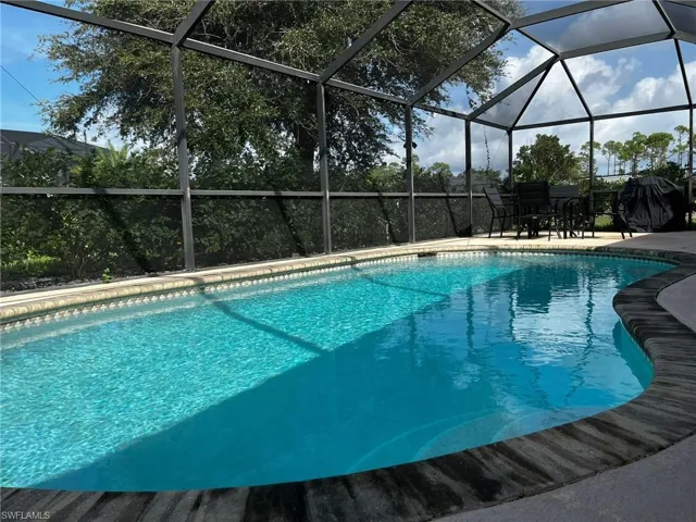View of swimming pool featuring a lanai and a patio area