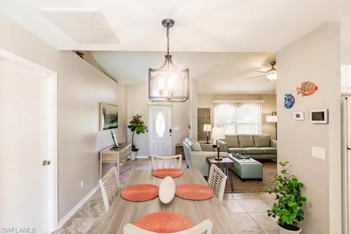 Dining room featuring ceiling fan with notable chandelier