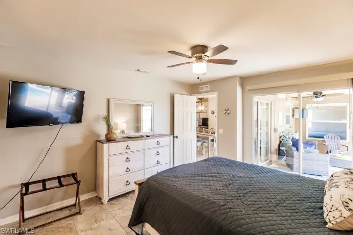Bedroom featuring ceiling fan, light tile patterned floors, and access to outside