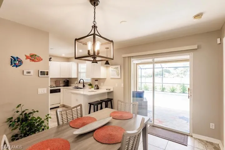 Tiled dining room with a chandelier, plenty of natural light, and sink