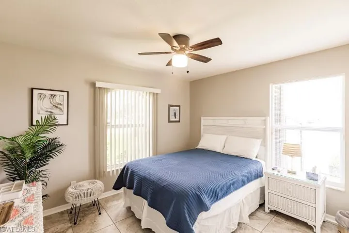 Bedroom with light tile patterned floors and ceiling fan