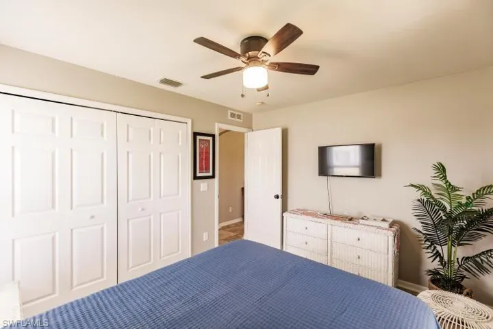 Unfurnished bedroom with ceiling fan and a closet