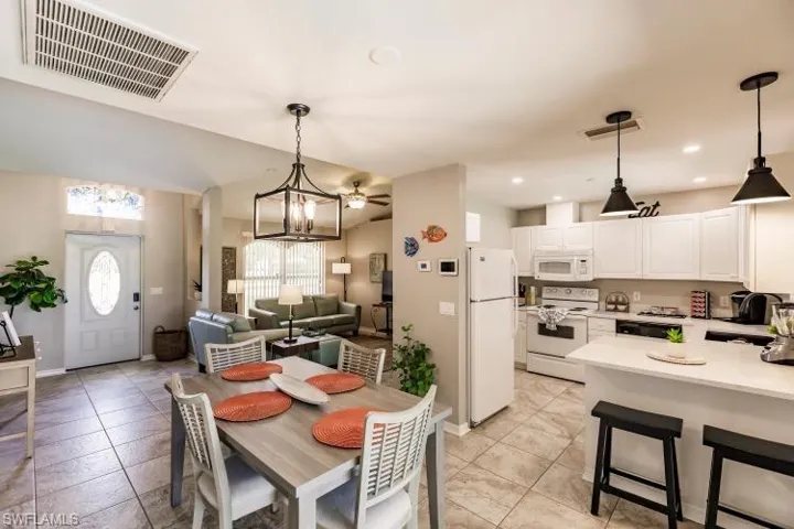 Dining space featuring ceiling fan with notable chandelier