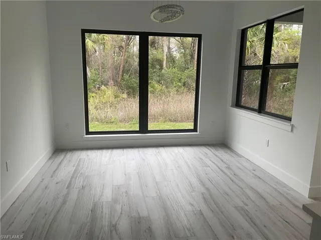 Spare room featuring light wood-type flooring and baseboards