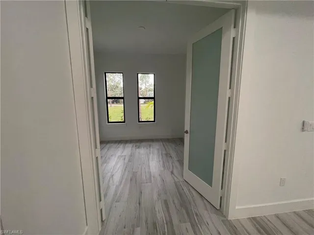 Hallway featuring baseboards and light wood-style flooring