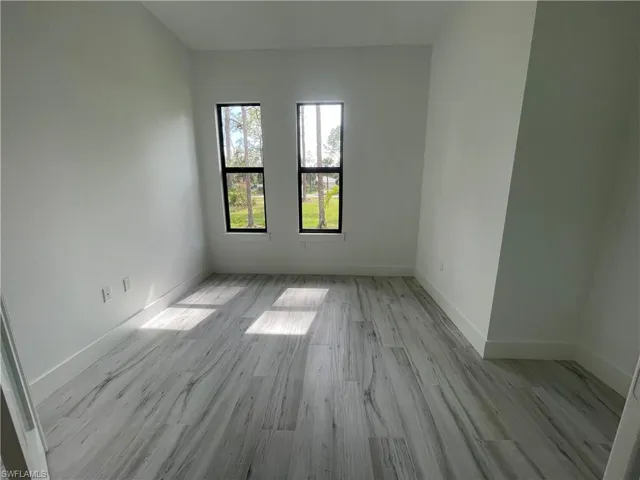 Unfurnished room with light wood finished floors and baseboards