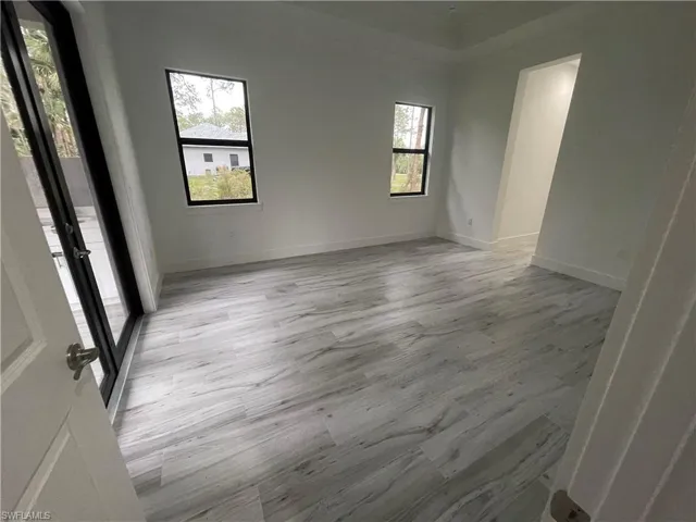 Spare room featuring light wood-type flooring and baseboards