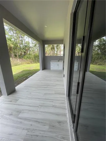 Wooden terrace with a patio area and a lawn