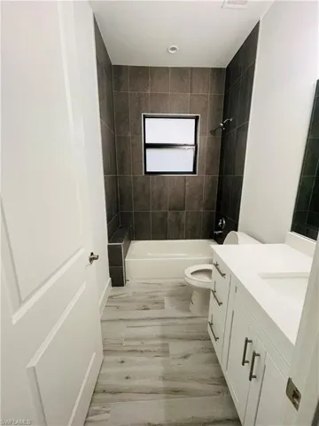 Full bathroom with vanity, bathing tub / shower combination, and light wood finished floors