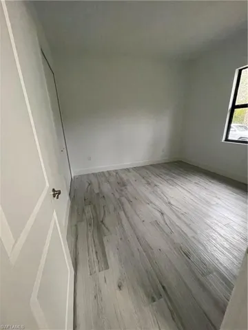 Unfurnished bedroom with light wood finished floors and baseboards