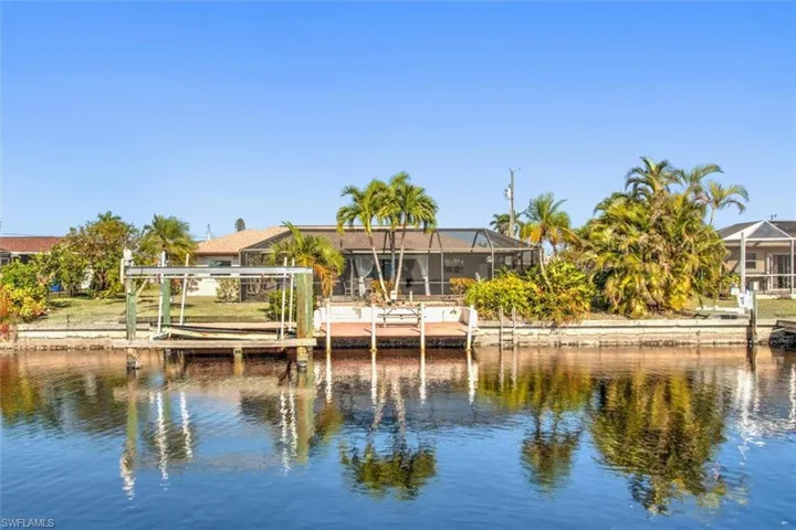 Back of house with a lanai, a water view, and a sunroom