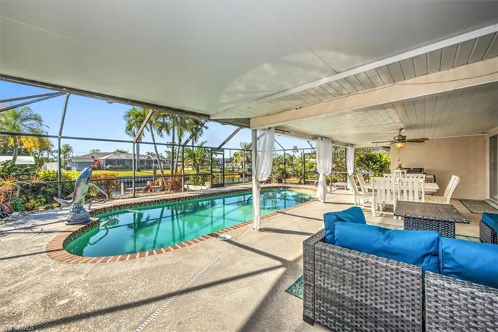 Outdoor pool with a patio, outdoor lounge area, a sunroom, and a lanai