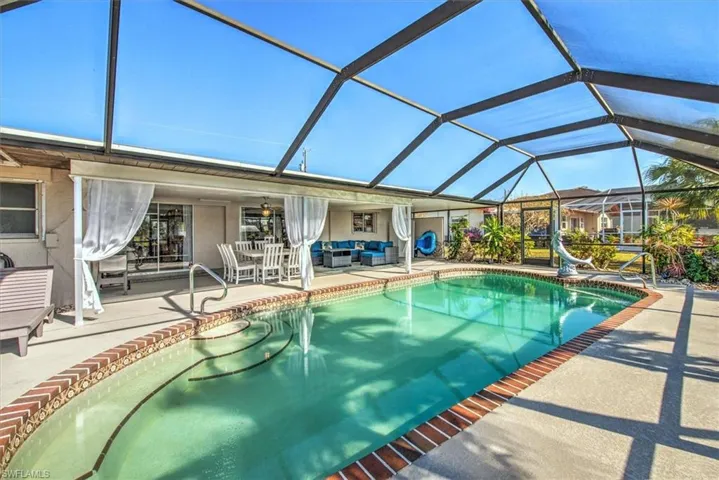 Outdoor pool featuring outdoor seating, glass enclosure, a patio area, and a sunroom