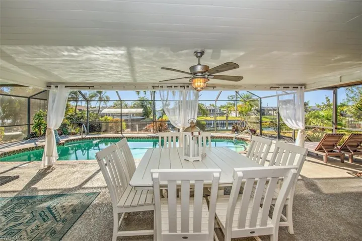 Swimming pool with a lanai, a patio area, a sunroom, and outdoor dining area