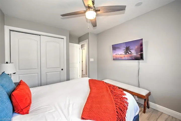 Bedroom with wood finished floors, a closet, and ceiling fan