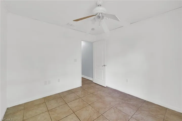 Spare room featuring a ceiling fan and light tile patterned flooring