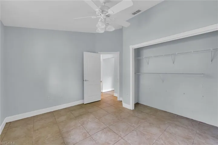 Unfurnished bedroom featuring a closet, ceiling fan, and tile patterned flooring