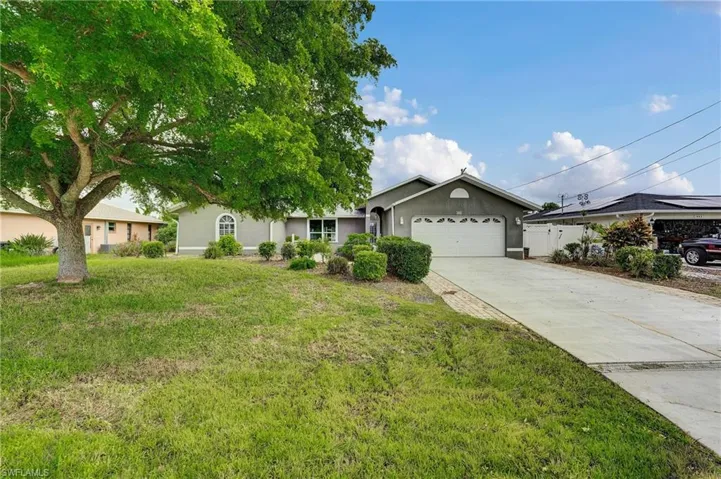 Ranch-style house featuring a garage, driveway, and stucco siding
