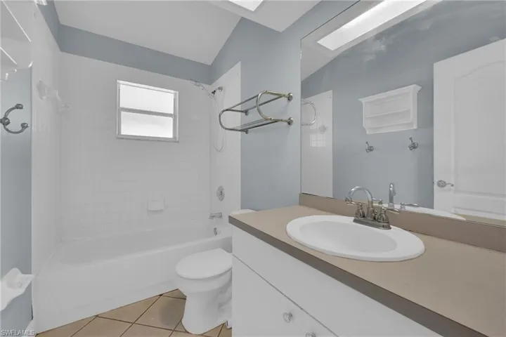 Bathroom featuring tile patterned flooring, shower / bathtub combination, and vanity
