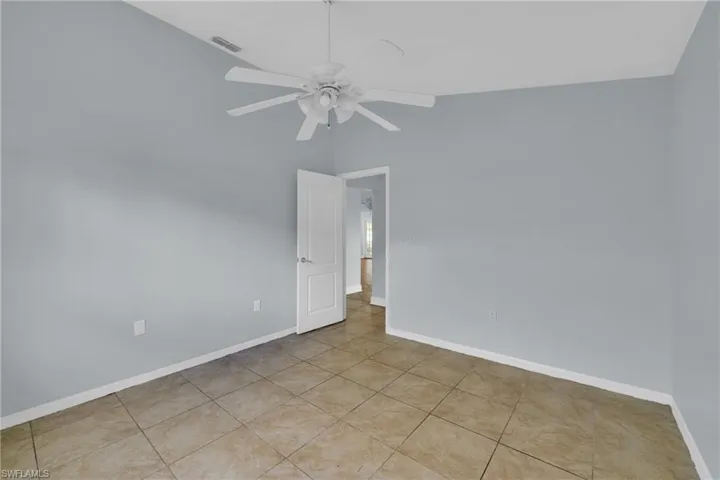 Empty room with a ceiling fan and lofted ceiling