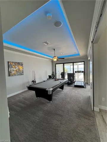 Playroom featuring a raised ceiling, crown molding, ceiling fan, carpet floors, and billiards table