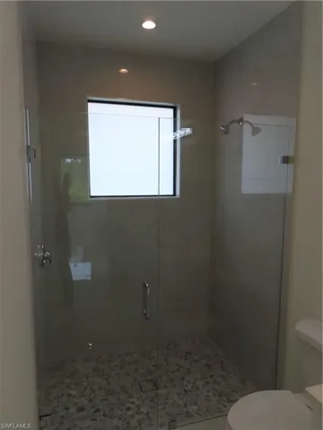 Bathroom featuring a shower stall and recessed lighting