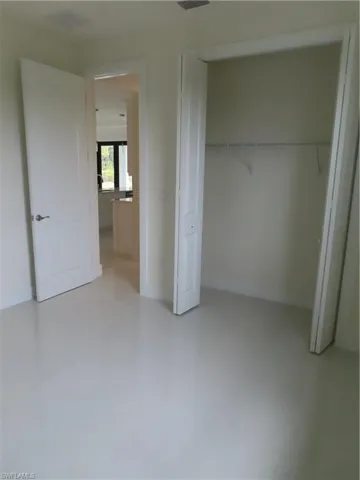 Unfurnished bedroom with a closet and concrete flooring