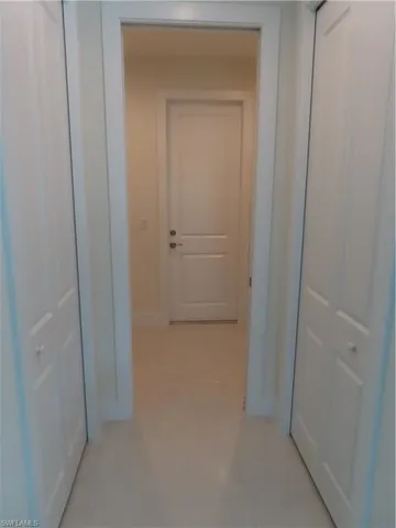 Hall featuring light tile patterned floors and baseboards