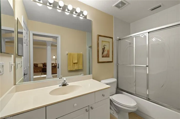 Full bathroom with vanity, combined bath / shower with glass door. Guest Bath