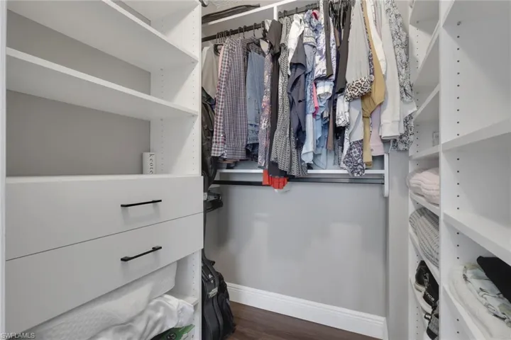 Walk in closet featuring dark wood-type flooring