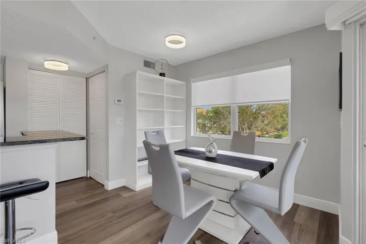 Dining area with a textured ceiling and dark wood-style floors