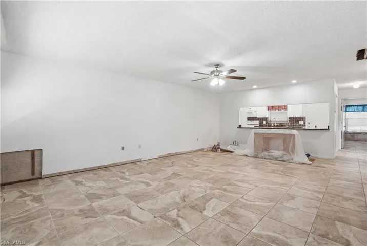 Unfurnished living room featuring a ceiling fan, recessed lighting, and a textured ceiling