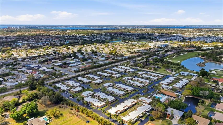 Aerial perspective of suburban area with a large body of water and a local golf course