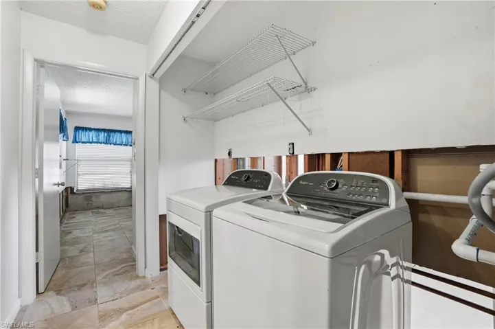 Laundry area featuring washing machine and dryer and a textured ceiling