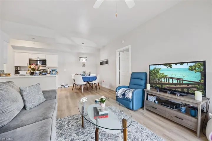 Living area with light wood-style floors and a ceiling fan