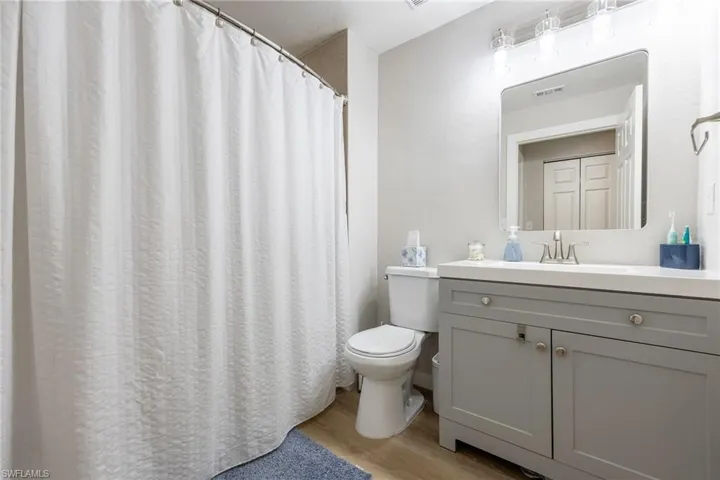 Bathroom featuring vanity, light wood-style flooring, and a shower with curtain