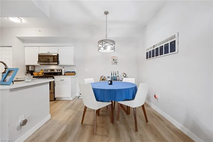Dining area with light wood-style floors and hanging lights