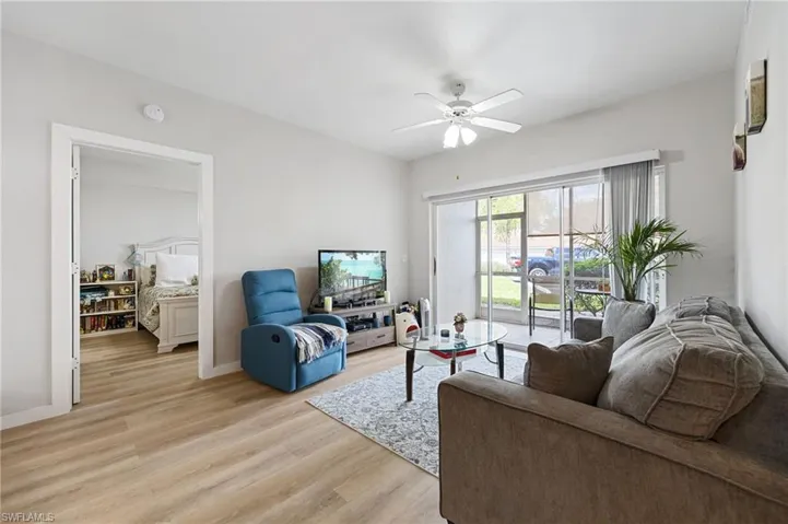 Living area with light wood-style flooring and a ceiling fan